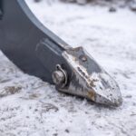 Macro detail of the replaceable hardened ripper point and its retaining pin
