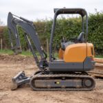 MX-10 mini excavator side profile showing the rubber tracks and retractable undercarriage