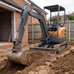 MX-10 mini excavator digging a foundation trench beside a house extension