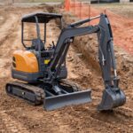 MX-25 mini excavator side profile with the boom extended into an open trench